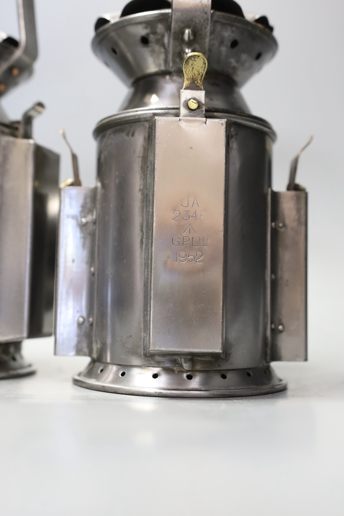 A pair of polished steel lamps, one dated 1945 - 30cm tall